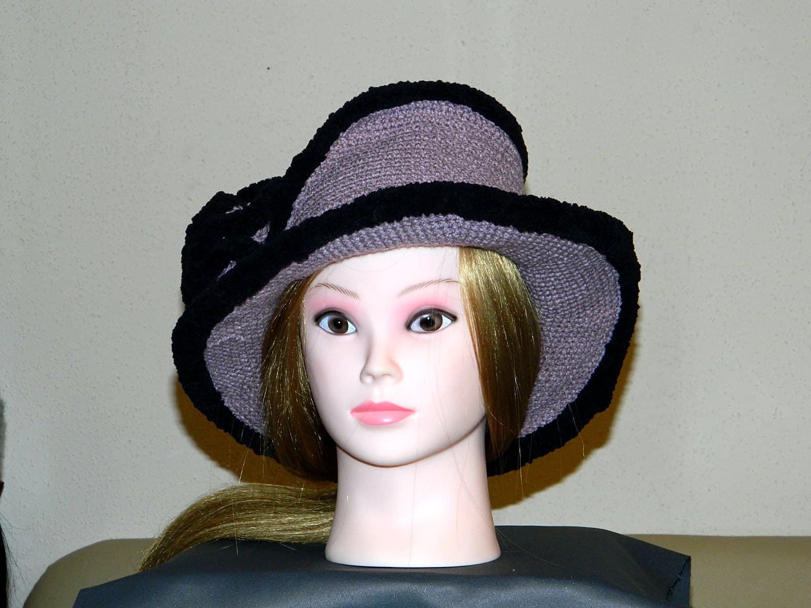 Breitkrempiger handgehäkelter Schlapphut in Mauve mit schwarzer Einfassung, von vorne