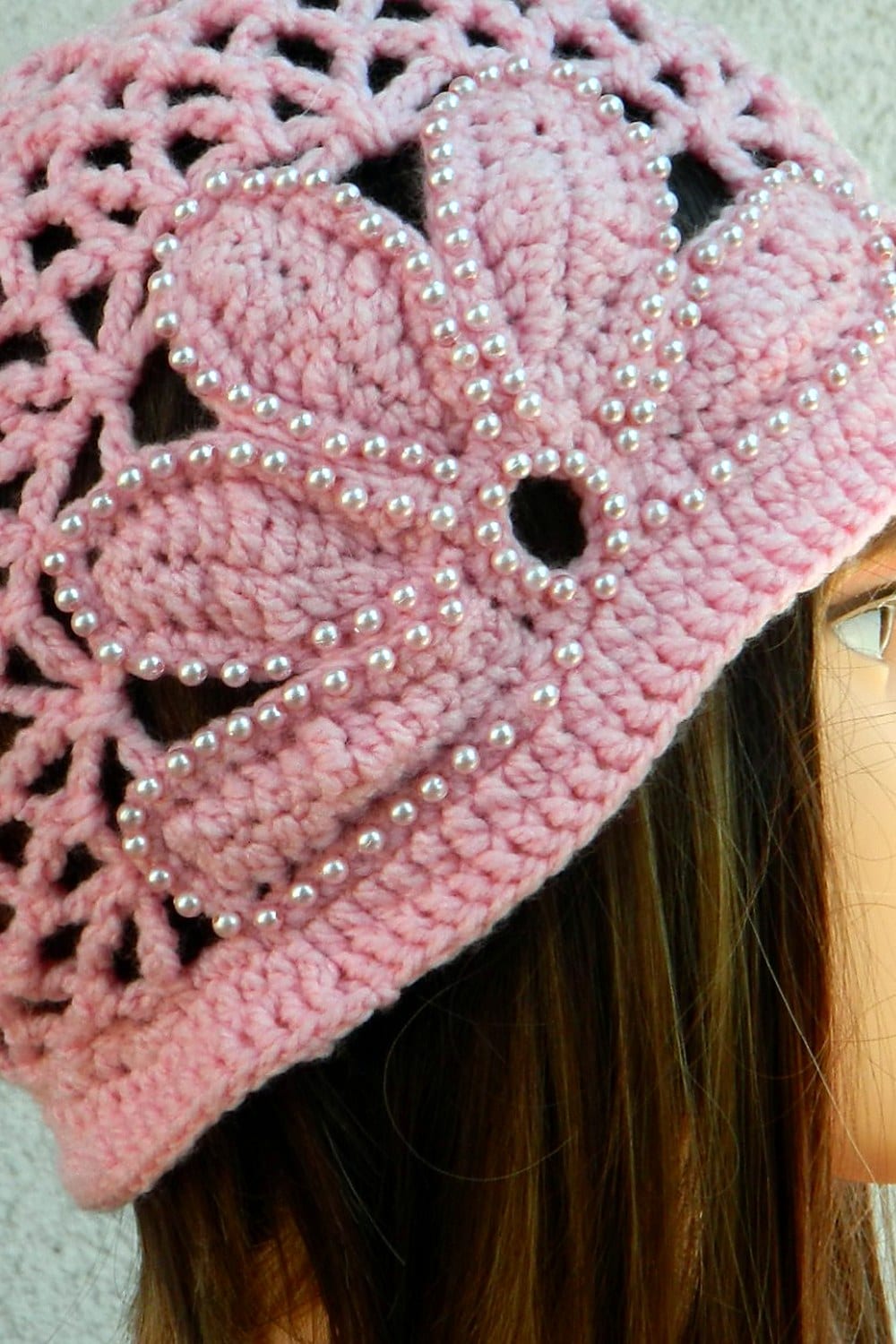 Die handgehäkelte Cloche „Perlmutt“ von Tina Burkert in Altrosa: das Blütenmuster aus fünf Blättern, jedes von Hand mit einzeln aufgenähten Perlen umrandet, im offenen Netzmuster der Haube